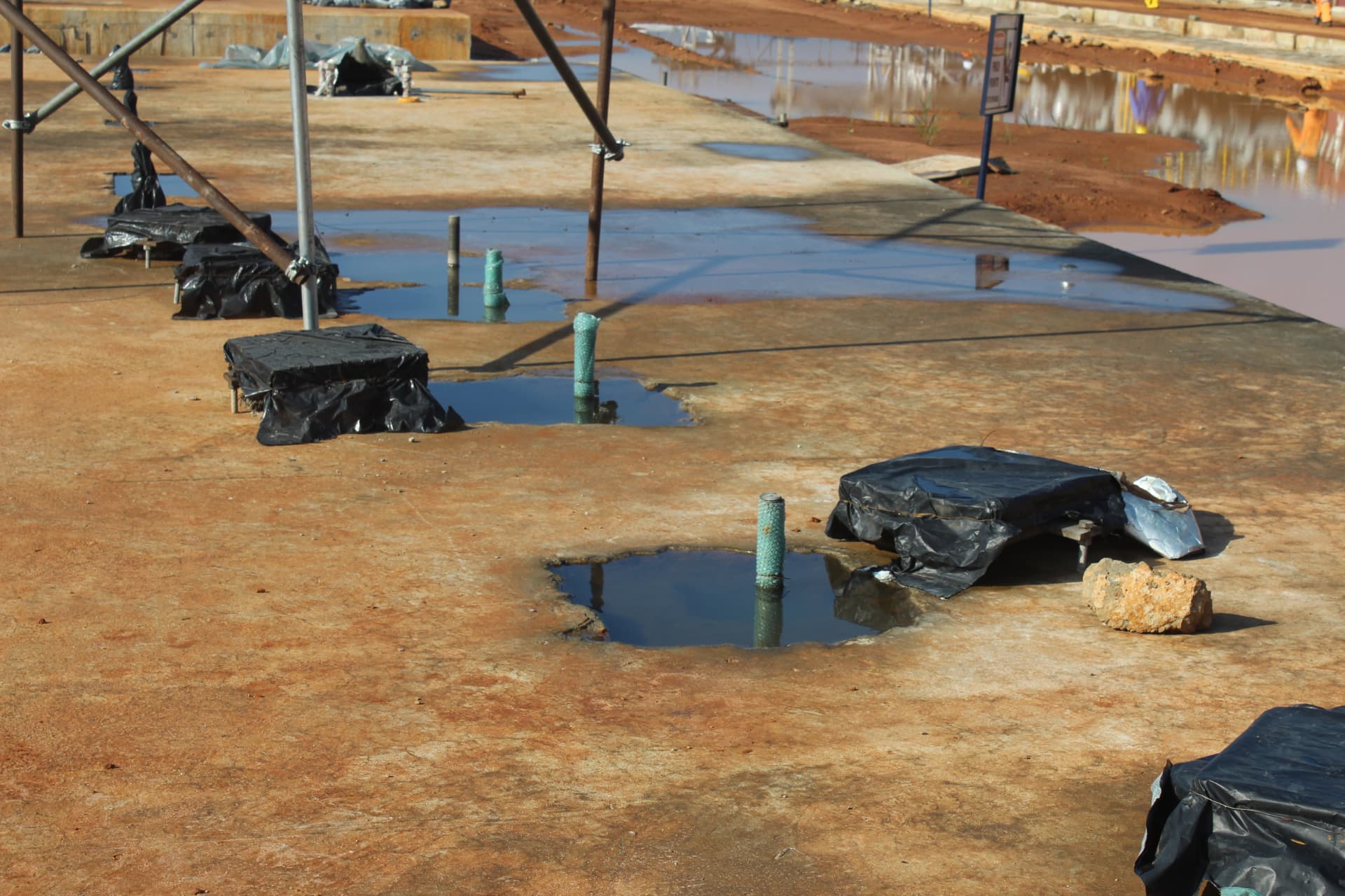 Row of prepared and covered grouting pockets along the plant foundation