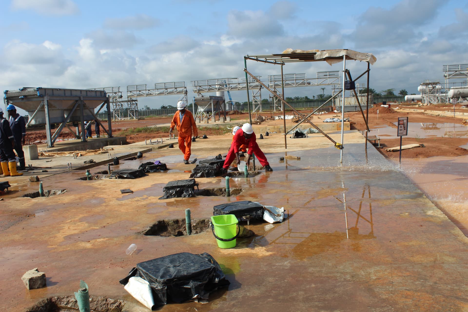 Crew placing grout across multiple foundation pockets on the plant slab
