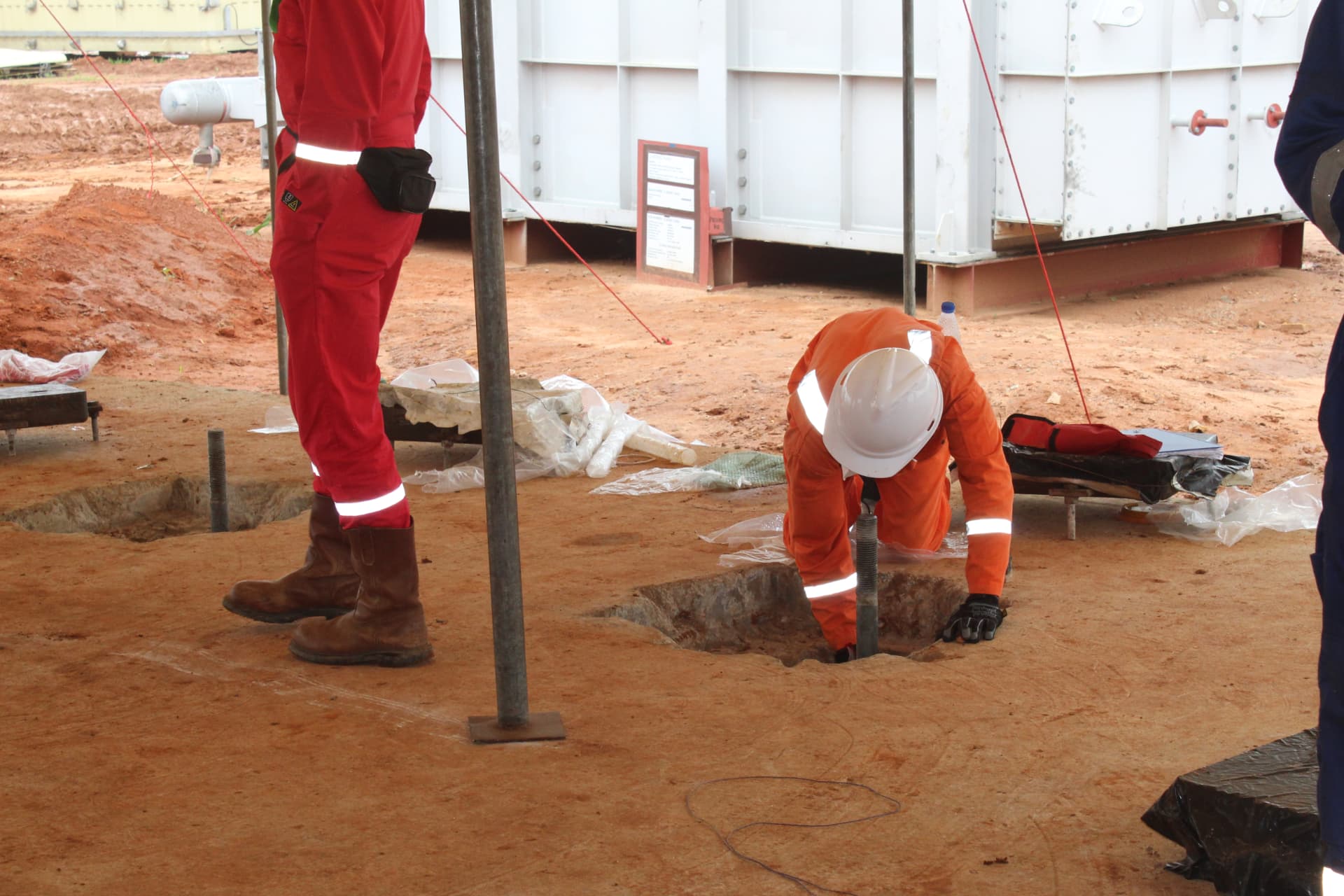 Operative preparing an anchor bolt pocket beside plant equipment skids