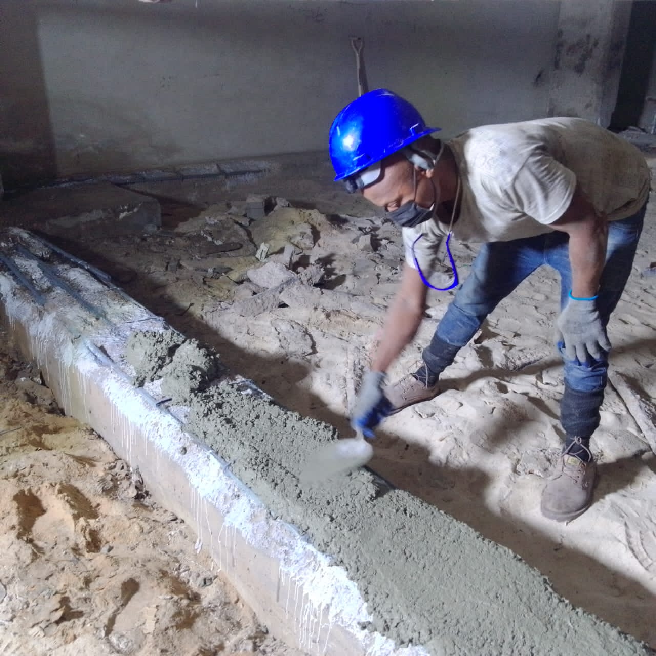Technician levelling freshly placed mortar on the repaired beam