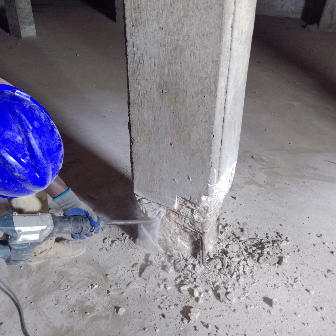 Breaking out spalled concrete at a basement column base