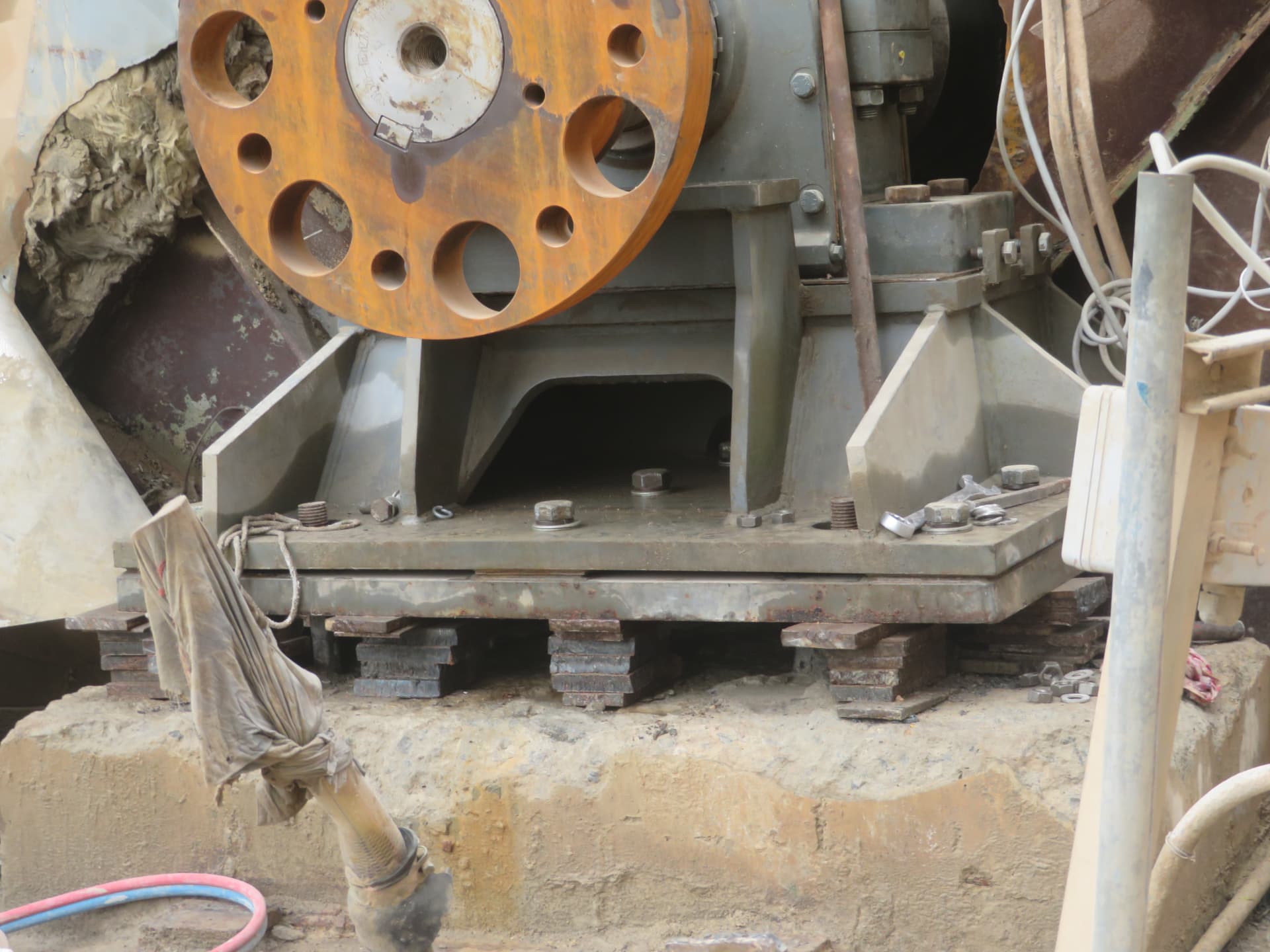 Close view of anchor bolts and shim packs under the base plate