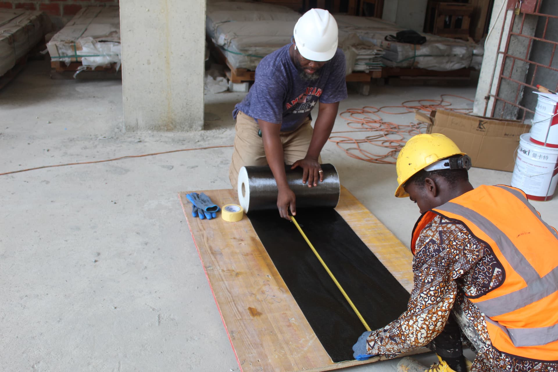 Team measuring carbon fibre fabric on a plywood cutting board
