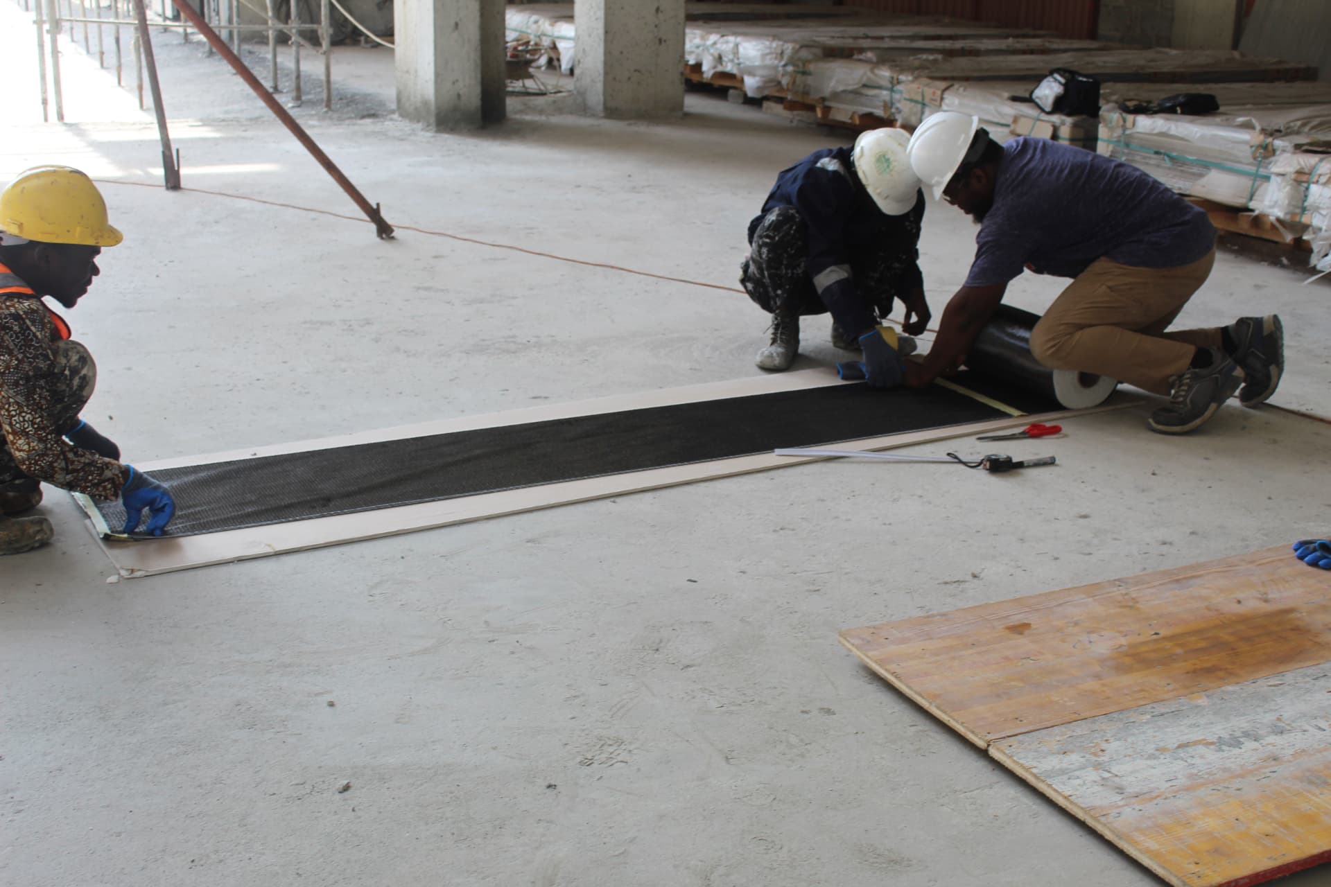 Crew measuring and setting out a length of carbon fibre wrap