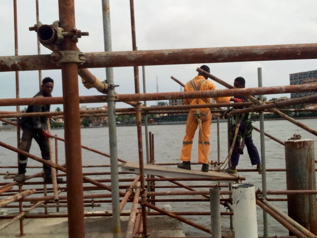 Crew erecting access scaffolding over the water at the jetty