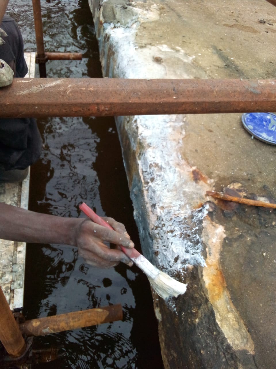 Brushing bonding primer onto the prepared concrete edge