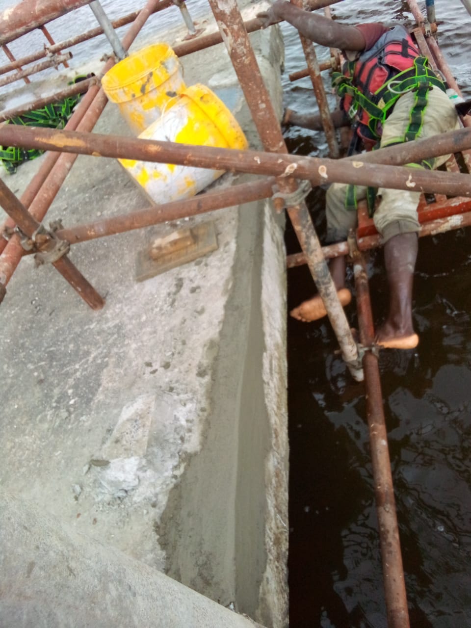 Repair crew working over open water beside the jetty beam