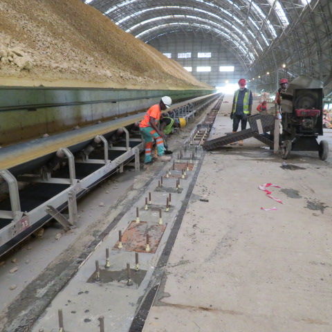 Anchor bolt groups and base plates set in the prepared rail trench