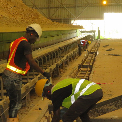 Team preparing anchor positions along the conveyor side