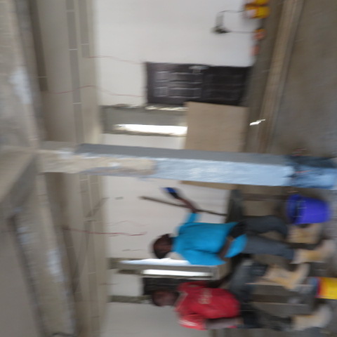 Operatives applying protective coating to a strengthened column
