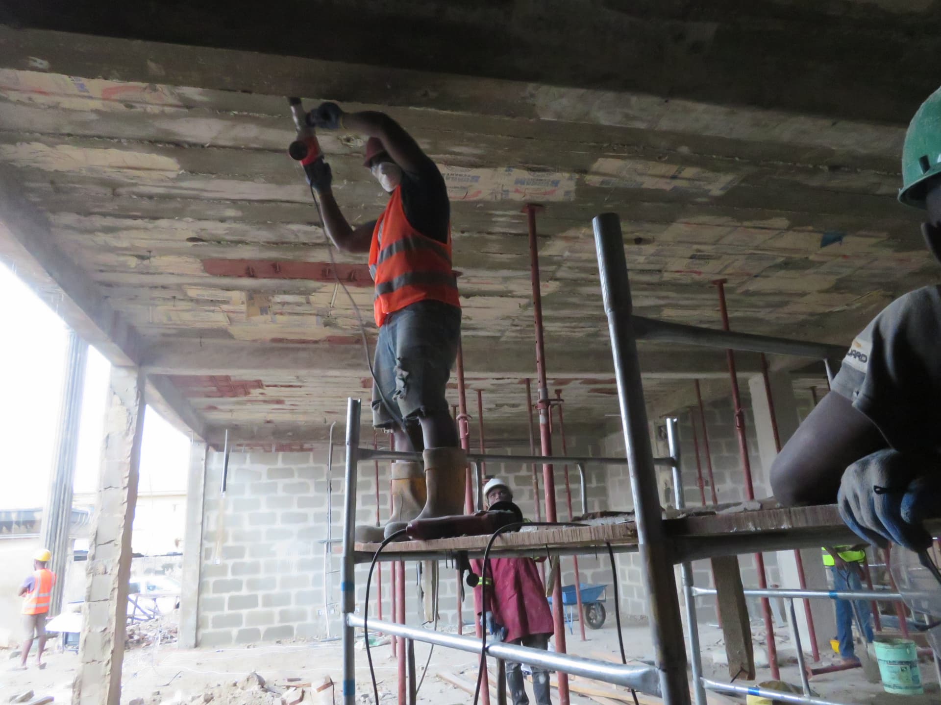 Operative scabbling a slab soffit from a scaffold platform