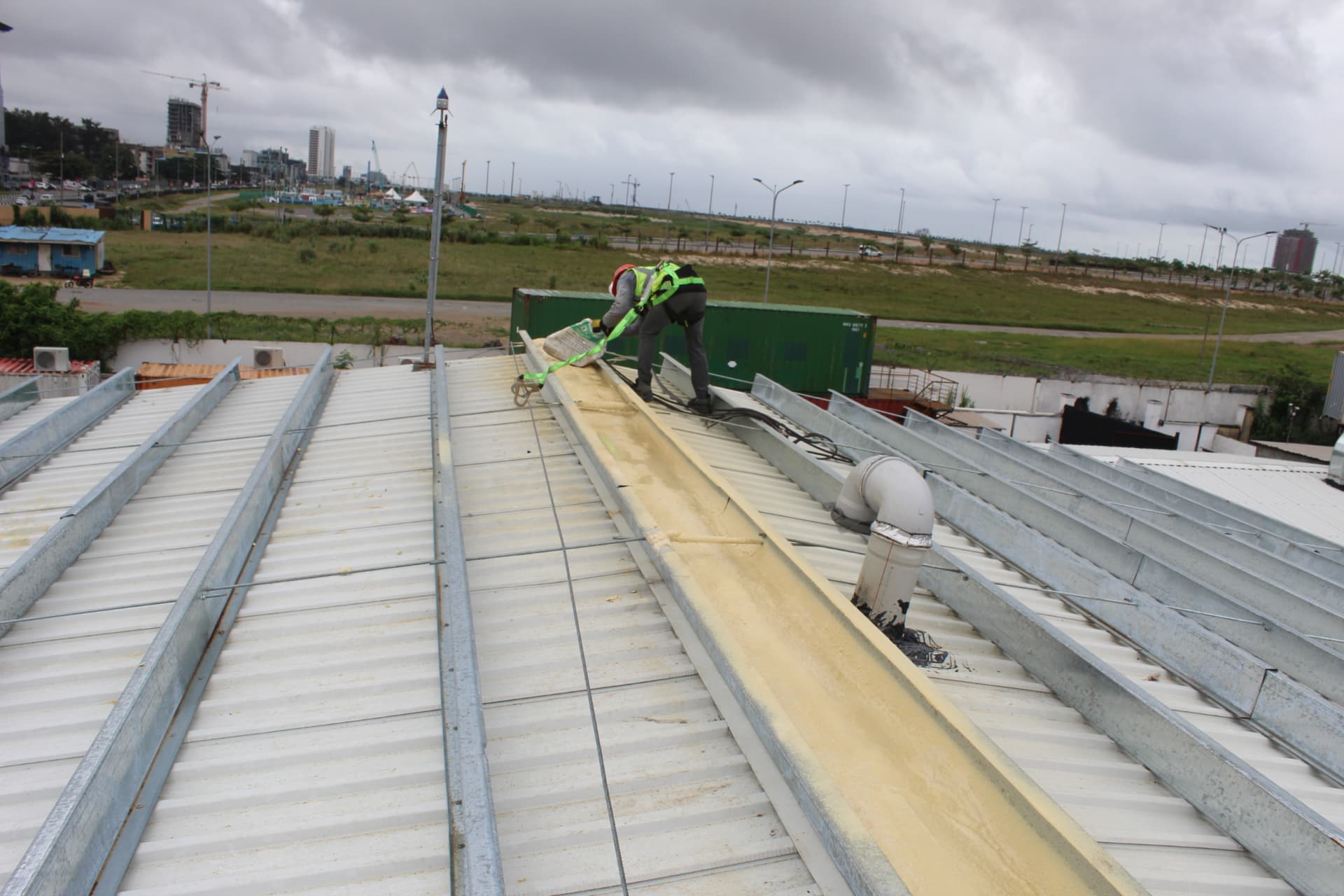 Worker applying spray foam to the roof gutter line