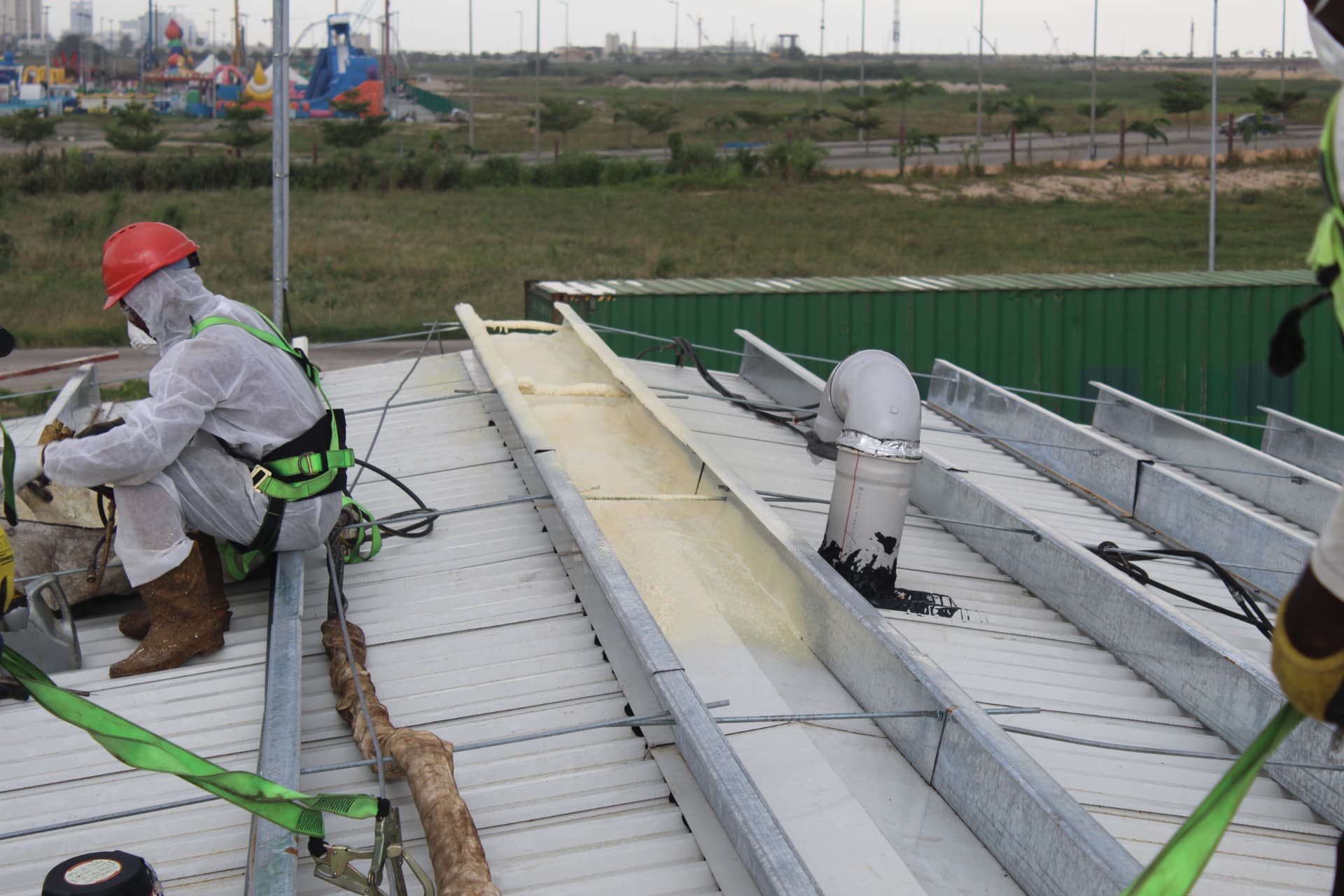 Technician preparing spray equipment beside the insulated roof channel