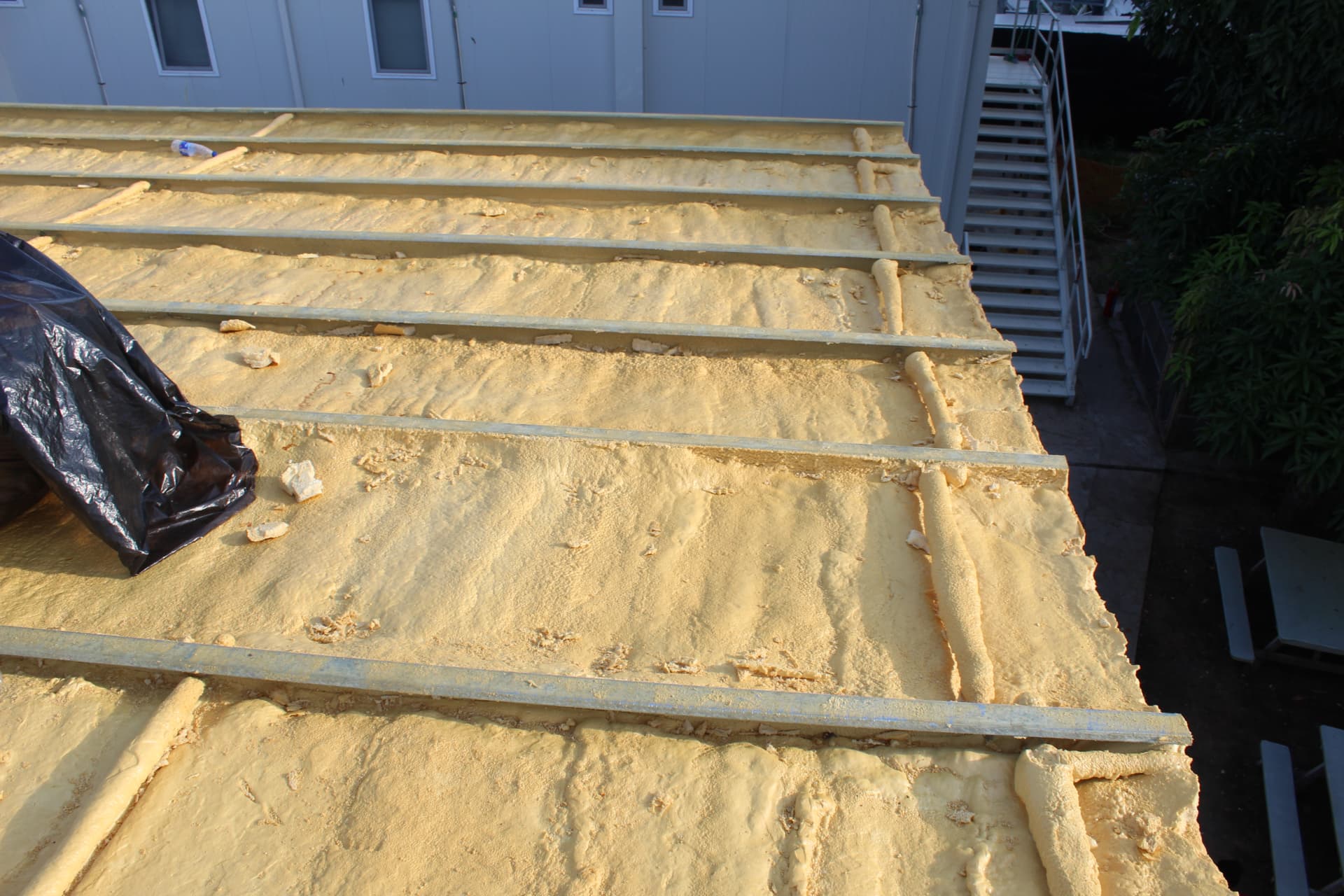Completed foam insulation between roof purlins seen from above