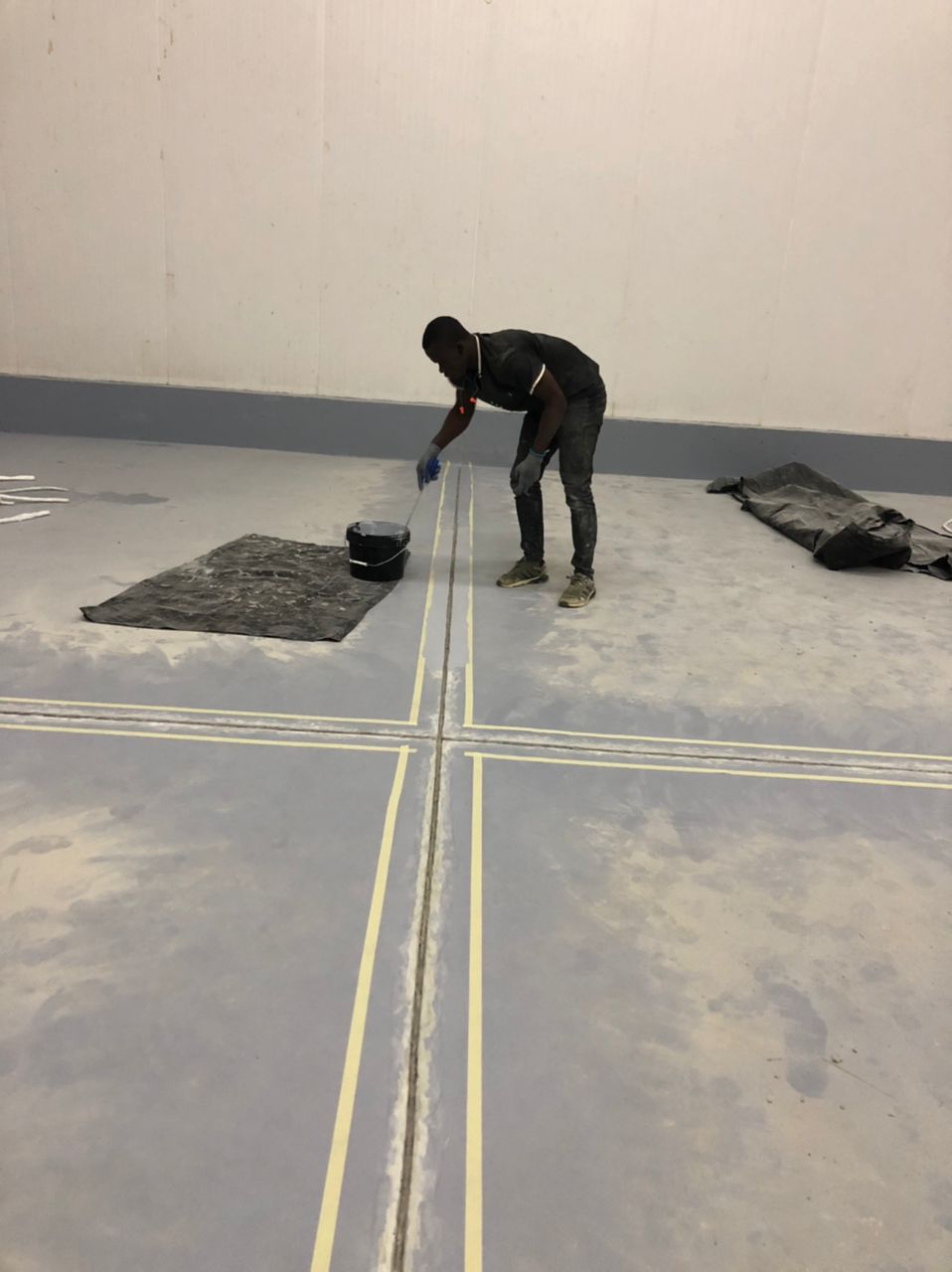 Applying sealant coating along a taped floor joint