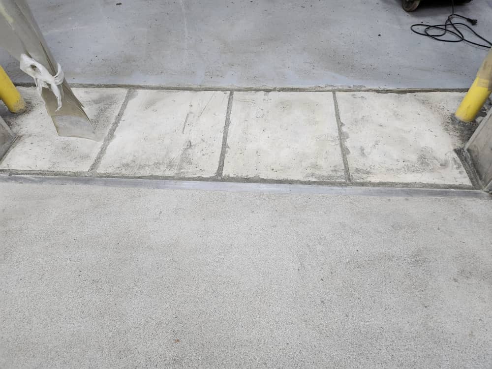 Surface preparation with hand grinder at delivery area doorway