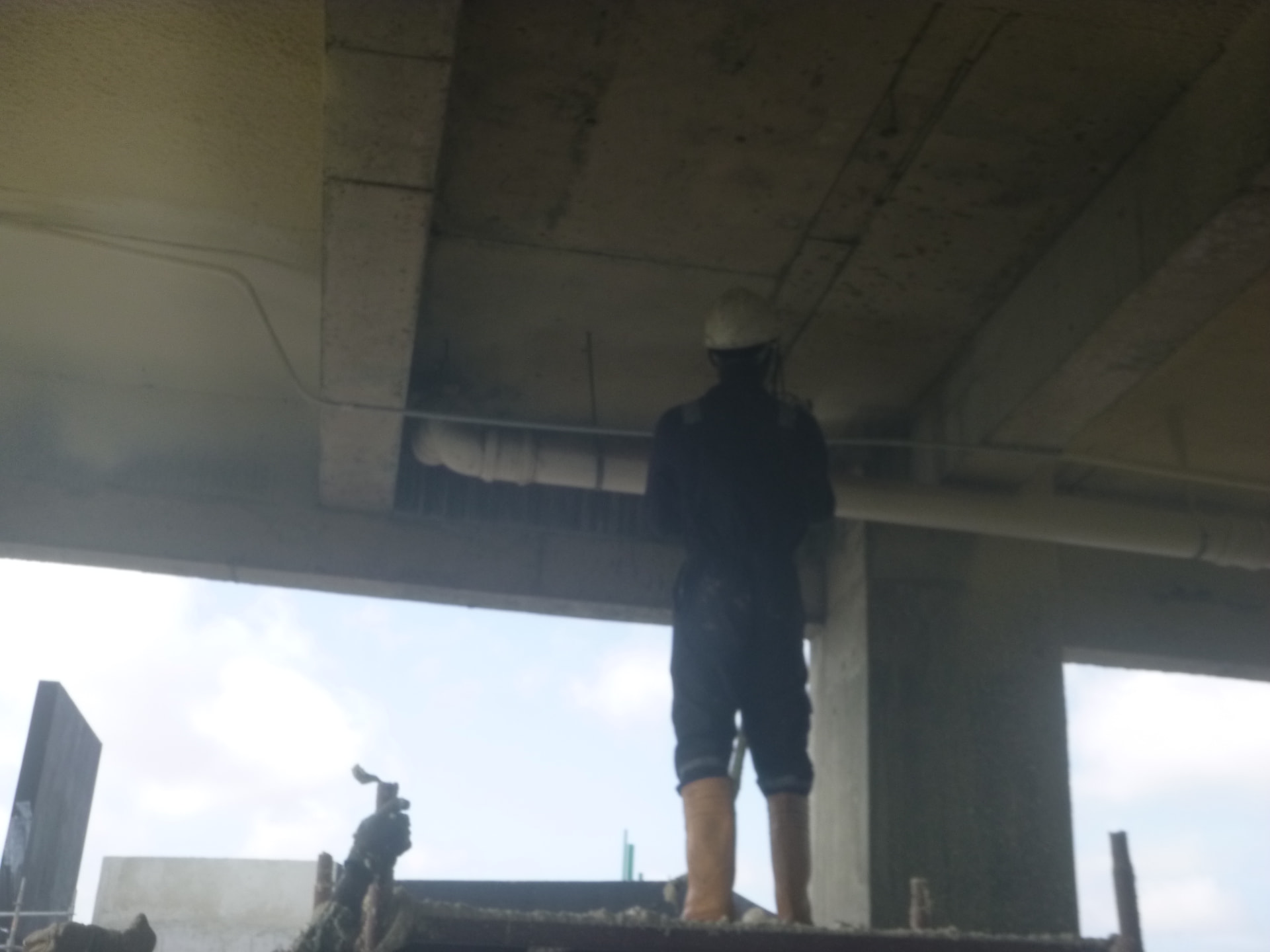 Technician insulating the soffit at the open perimeter of the tower floor