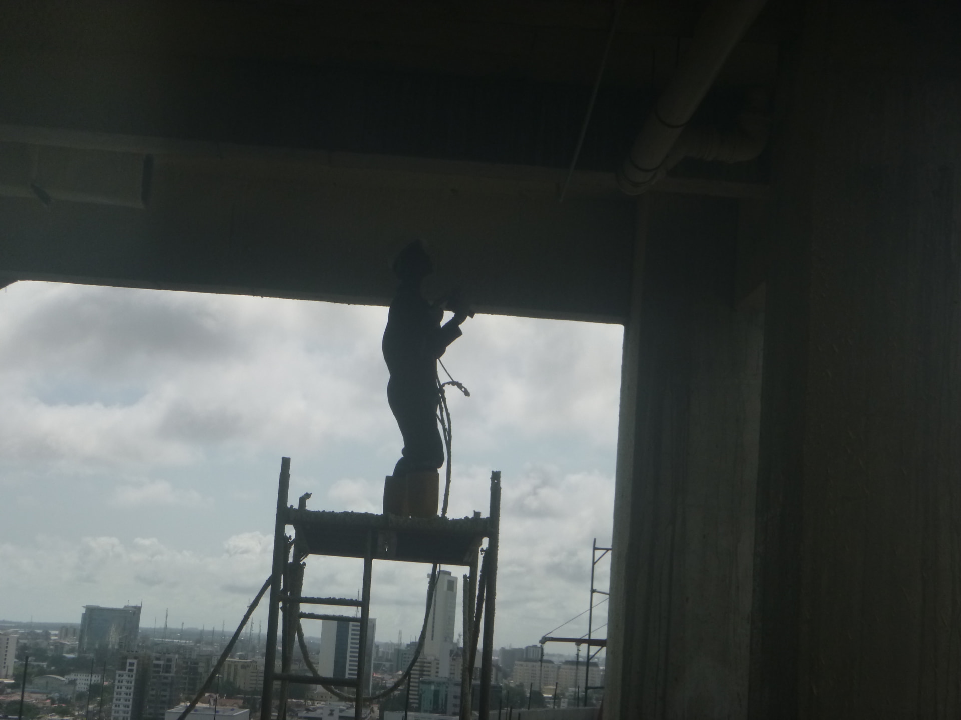 Operative on a mobile tower platform spraying insulation to a high beam