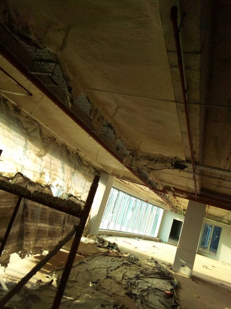 Protective sheeting draped below the soffit during spray application