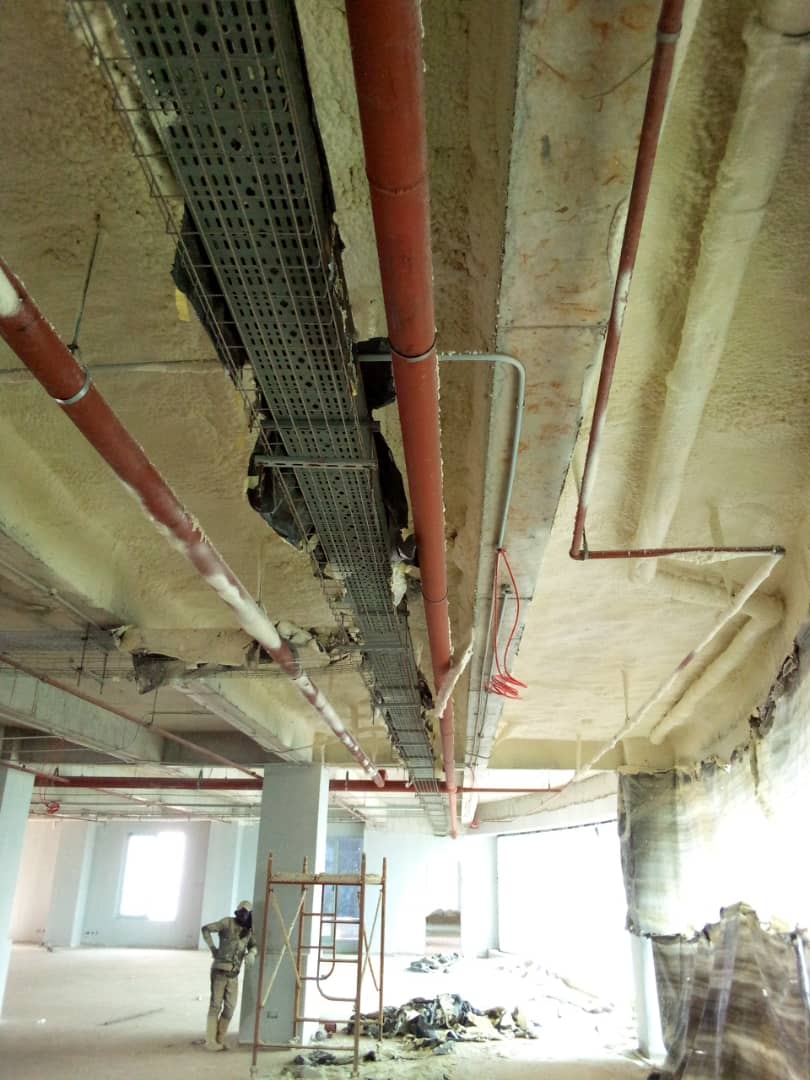 Insulated soffit with cable trays and services across an unfinished office floor